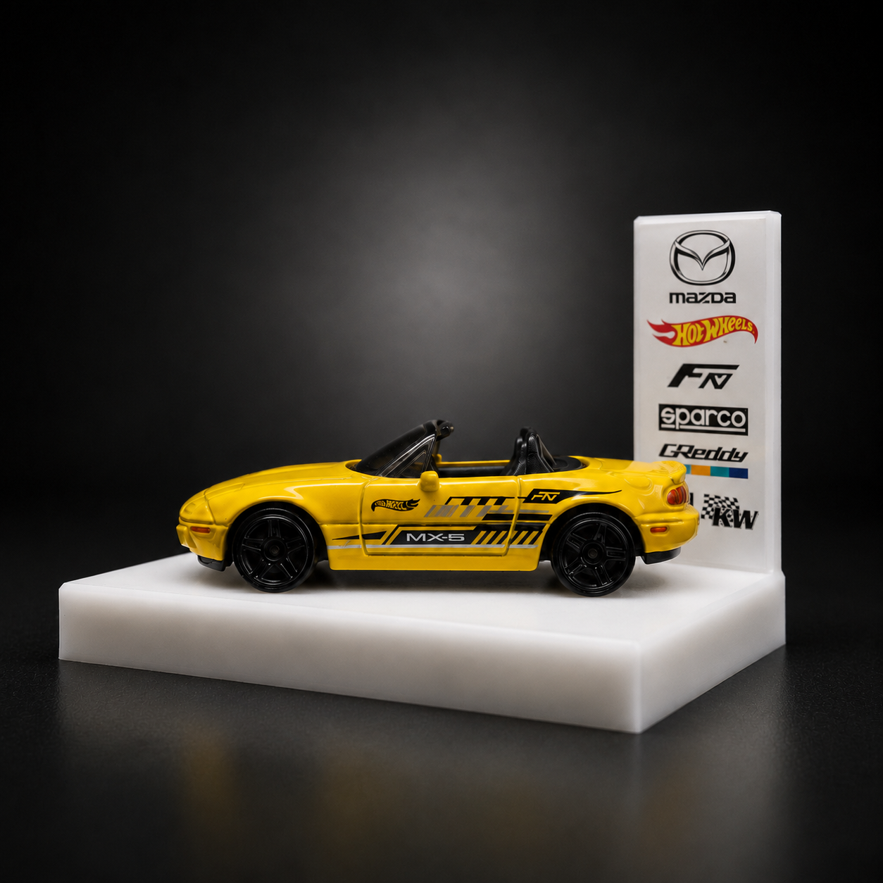 RallyStage display base with 1:64 diecast MX-5, backdrop card branded with the car's real-world liveries